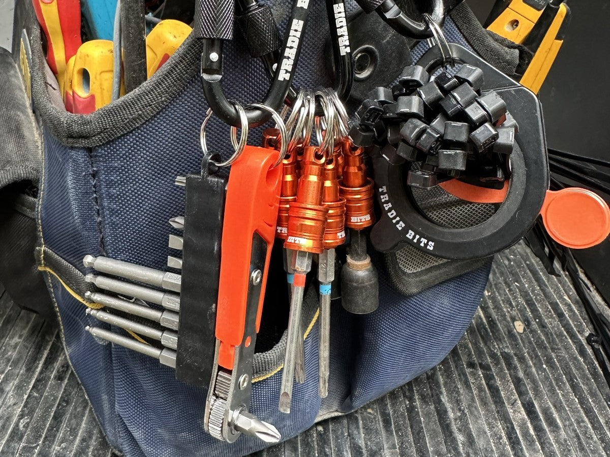 All three Smarter Not Harder Kit tools clipped to a tradie's tool bag